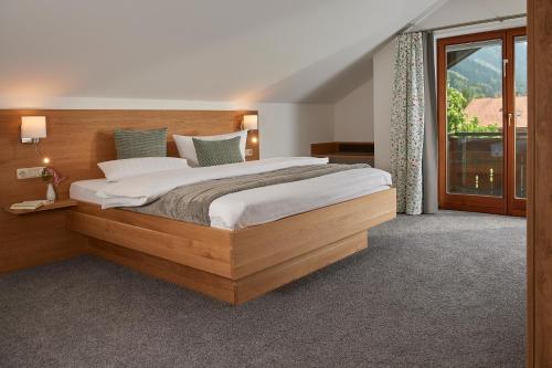 a bedroom with a large bed and a large window at Gästehaus Hornblick in Oberstdorf