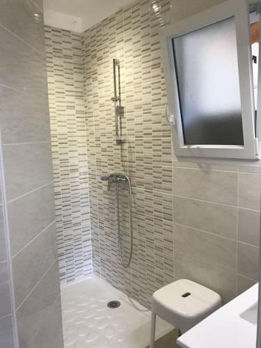 a bathroom with a shower and a tv on the wall at Cocon aux portes des Cévennes avec piscine in Moulès-et-Baucels