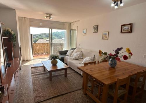 ein Wohnzimmer mit einem Sofa und einem Tisch in der Unterkunft Apartamento Vacacional en Platja D'Aro in S'Agaró