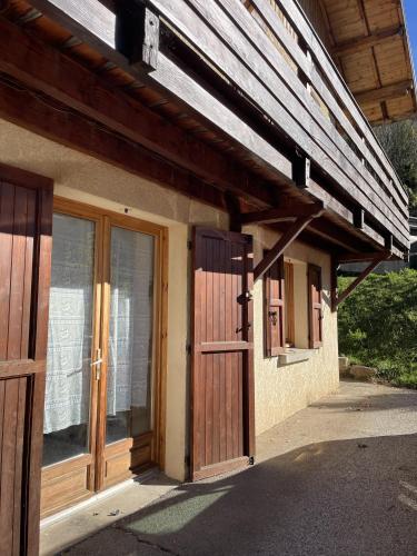 a building with a wooden door and windows at Appartemant La Gardette in Le Puys