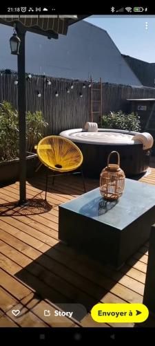 eine Terrasse mit einem Tisch, einem Stuhl und einem Sonnenschirm in der Unterkunft Charmante Villa Piscine/Jaccuzzi Béziers in Béziers
