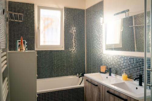 ein Badezimmer mit einem Waschbecken, einer Badewanne und einem Waschbecken in der Unterkunft Charmante Villa Piscine/Jaccuzzi Béziers in Béziers