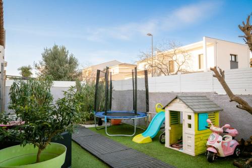 einen kleinen Hinterhof mit einem Spielset und einem Trampolin in der Unterkunft Charmante Villa Piscine/Jaccuzzi Béziers in Béziers