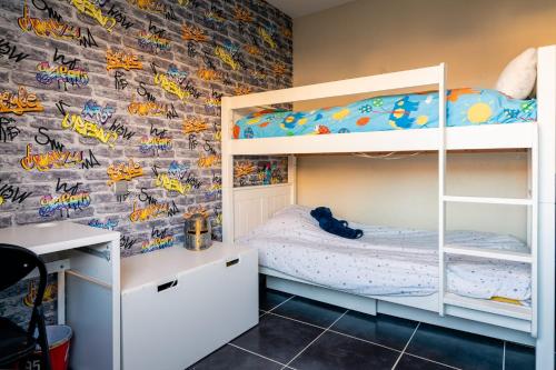 Schlafzimmer mit Etagenbetten und Ziegelwand in der Unterkunft Charmante Villa Piscine/Jaccuzzi Béziers in Béziers