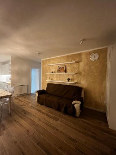 uma sala de estar com um sofá e um piso de madeira em Claretta’s Home em Iglesias