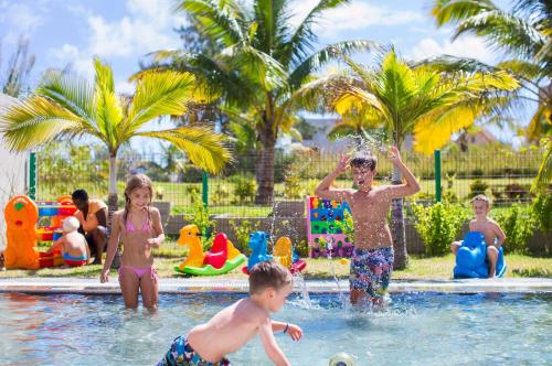 a group of children playing in a swimming pool at Crystals Beach Resort Belle Mare, a member of Radisson Individuals in Belle Mare