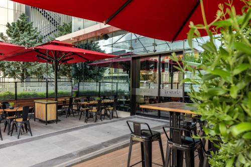 a restaurant with tables and chairs and red umbrellas at The Plaza Hotel Edirne in Edirne