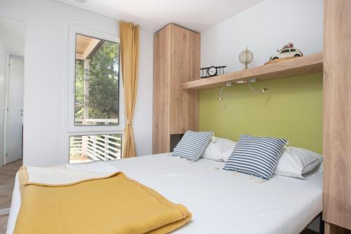- une chambre avec un lit doté d'oreillers bleus et blancs dans l'établissement Camping Stobreč Split, à Split