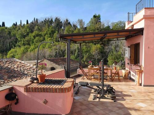 une terrasse avec un barbecue et une table sur une maison dans l'établissement Il Casale la Lupa, à Nunziata