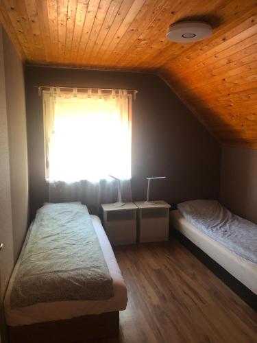 1 Schlafzimmer mit 2 Betten und einem Fenster in der Unterkunft Bonita Apartman in Balatonberény