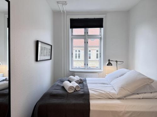 a white bedroom with a bed with towels on it at Two Bedroom Apartment In Copenhagen, Woltersgade 9, in Copenhagen