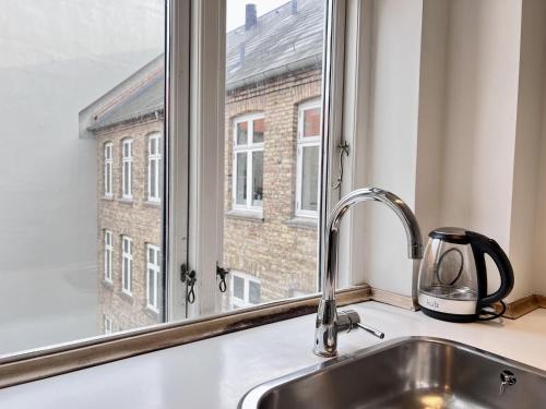 a kitchen sink with a window looking out at a building at Two Bedroom Apartment In Copenhagen, Woltersgade 9, in Copenhagen