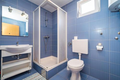 a blue bathroom with a toilet and a sink at House Harry near Supermarket and Center in Novalja