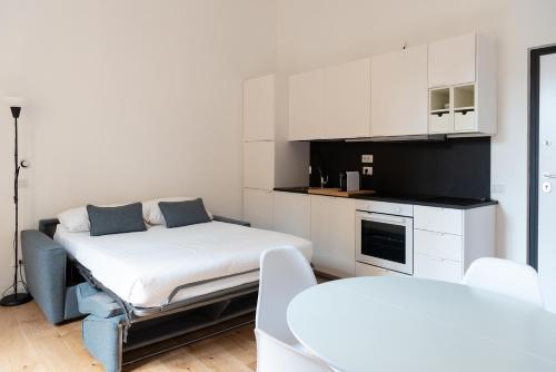 a room with a bed and a kitchen with white cabinets at designer apartment via nazionale in Rome
