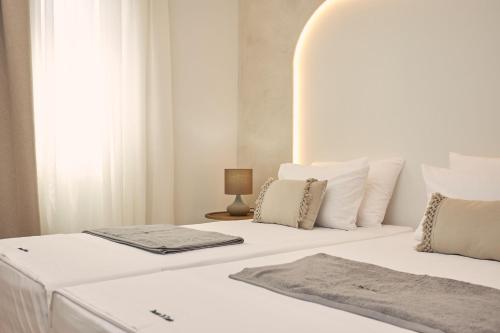 two beds with white sheets and pillows in a room at Ducato di Zante Luxury Beach Villa, by ZanteWize in Kipseli