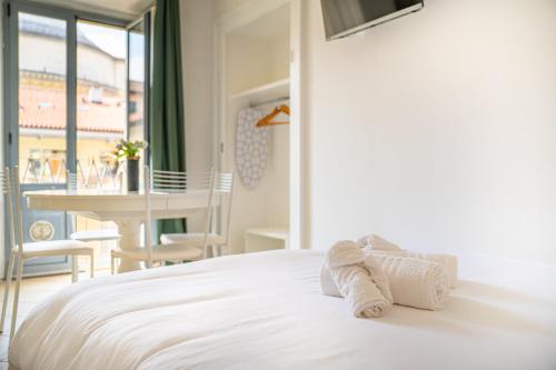 Un dormitorio con una cama blanca con toallas. en Loft Verga, cuore e stile in centro a Torino en Turín
