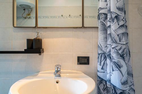 baño con lavabo y cortina de ducha en Loft Verga, cuore e stile in centro a Torino en Turín