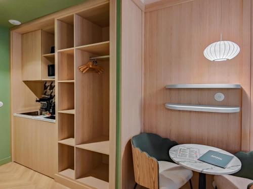 a room with a table and a book shelf at Aparthotel AMMI Nice Lafayette in Nice