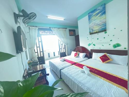 a bedroom with two beds and a large window at Bách Khoa Motel in Vung Tau