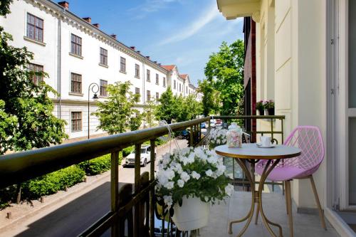 Un balcón con una mesa y sillas y una calle. en Rajska Residence en Cracovia