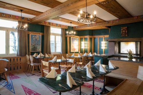 a dining room with tables and chairs in it at Hotel Drei Berge in Mürren