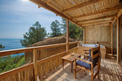 una terraza de madera con bañera, mesa y sillas en Flavia Hotel, en Kızılcakaya