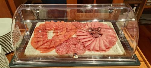 a glass container filled with different types of meat at Sporthotel Victoria in Gstaad