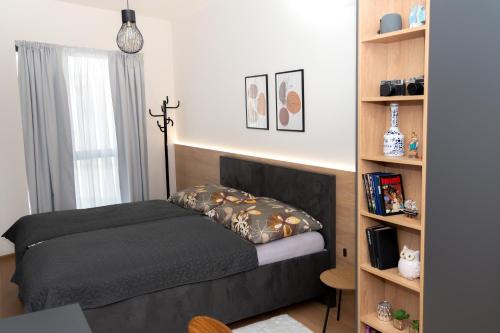 a bedroom with a bed and a book shelf at Apartmán Breeze in Stará Lesná