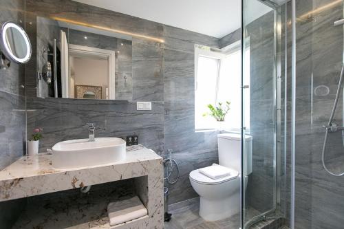 y baño con lavabo, aseo y ducha. en Azalea Villa Sani, Sani Luxury Villas Collection en Sani Beach
