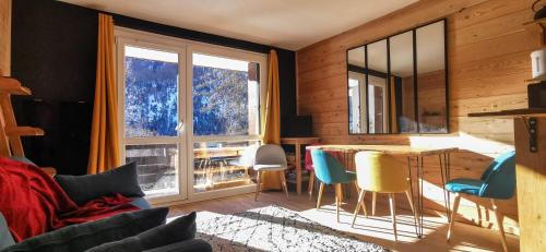 a living room with a table and chairs and a large window at Studio 4/5 personnes au pied des pistes Les Orres in Les Orres