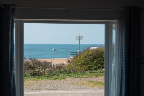 a view of the beach from a window at Fisherman's Daughter in Dorchester