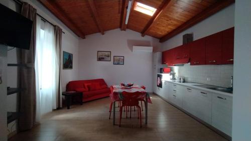 cocina con mesa y sofá rojo en Perdanoa - ApartHotel - F1469, en Ghilarza