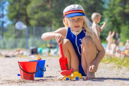 a little girl playing with a toy in the sand at Camp Gielas, Arvidsjaur in Arvidsjaur