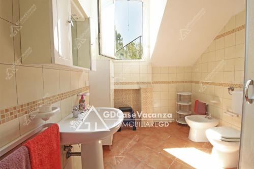 a bathroom with a sink and two toilets at GD Case Vacanza - Ville del Rio in Fontanelle