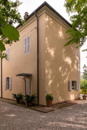 a large white building with plants in front of it at Casa nella campagna Parmigiana. in Stradella
