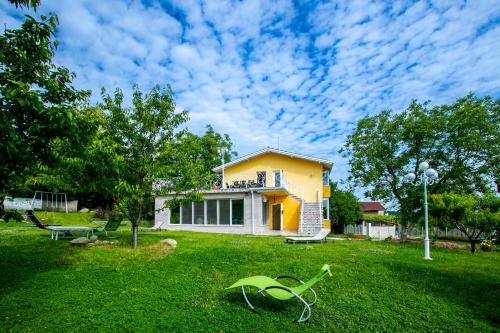 una casa en un patio con césped verde en Къща за гости Кала, en Patalenitsa