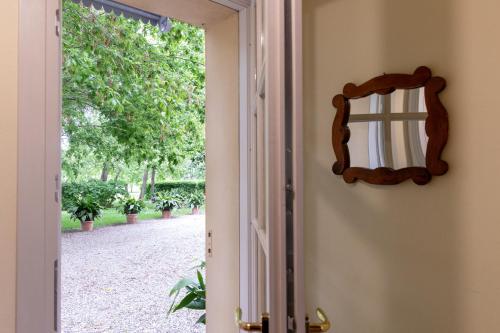 a mirror on a wall next to a door at Casa nella campagna Parmigiana. in Stradella