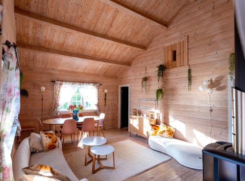 uma sala de estar com paredes de madeira e um tecto de madeira em Cabin near the lake em Årset