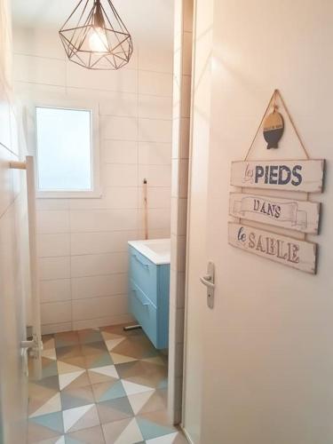 une salle de bain avec un lavabo et des toilettes et une porte dans l'établissement La Maraîchine Ensoleillée, à Saint-Jean-de-Monts