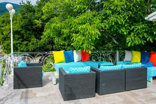 a couch with colorful pillows sitting on a patio at Къща за гости Кала in Patalenitsa