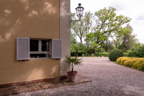 a plant in a pot next to a building with a window at Casa nella campagna Parmigiana. in Stradella