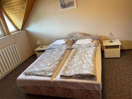 uma cama num pequeno quarto com duas mesas em Apartments in Gyenesdias/Balaton 39946 em Gyenesdiás
