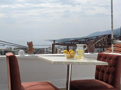 a table with a bowl of fruit on a balcony at Best sunset & sunrise budget rooms in Mytilini