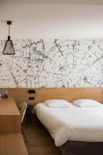 a bedroom with a bed and a drawing on the wall at L'AO Hôtel & Restaurant L'Aigle d'Or in Rimbach-près-Guebwiller
