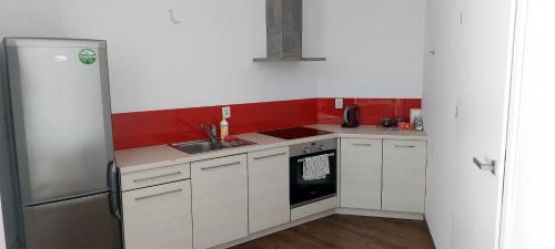 a small kitchen with white cabinets and a refrigerator at Cube Apartamenty in Lublin