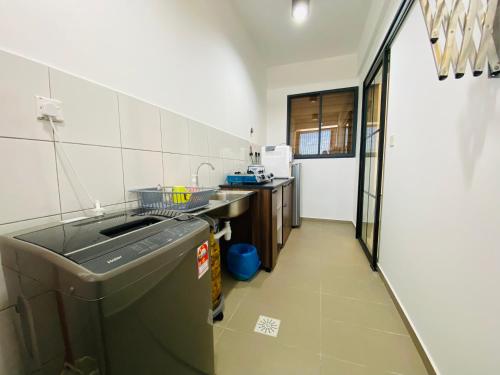 a kitchen with a sink and a dishwasher at Proboscis Guest House Monthly in Sandakan
