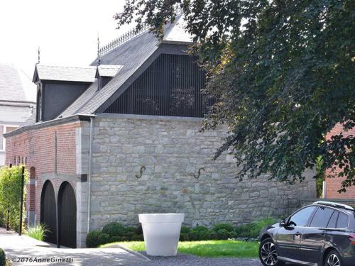 a black car parked in front of a brick building at Hôtel Le Manoir in Marche-en-Famenne