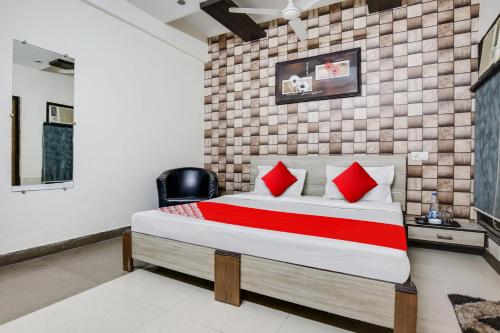 ein Schlafzimmer mit einem großen Bett mit roten Kissen in der Unterkunft OYO Flagship Hotel Skyorchid in Ābādpura