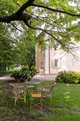a table and two chairs in the yard of a house at Casa nella campagna Parmigiana. in Stradella