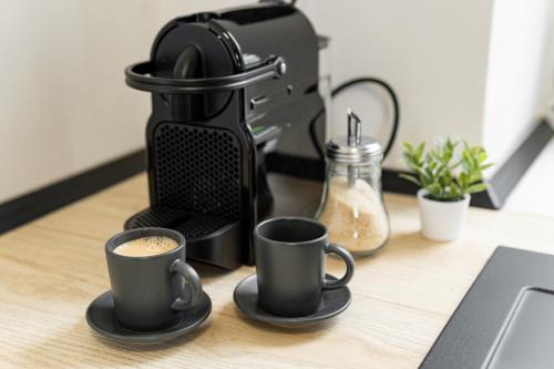 two cups of coffee sitting on a table at Beautiful Apartments With Parking In a Quiet Location in Ostrava
